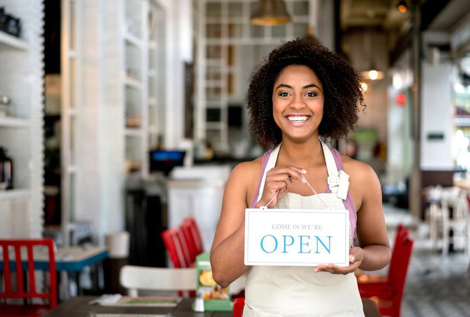 Woman holding an "open" sign