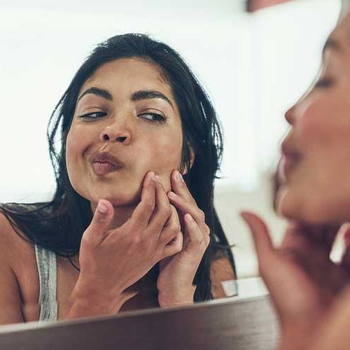 Woman squeezing zit