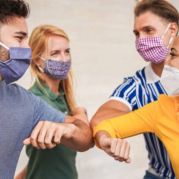 Friends bumping elbows instead of shaking hands.