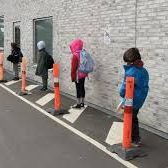Children social distancing while waiting in line.