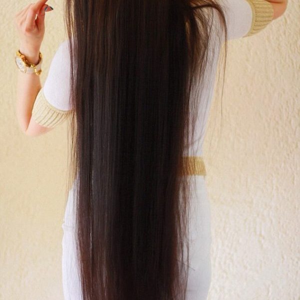 Woman in white outfit with long, brunette hair.