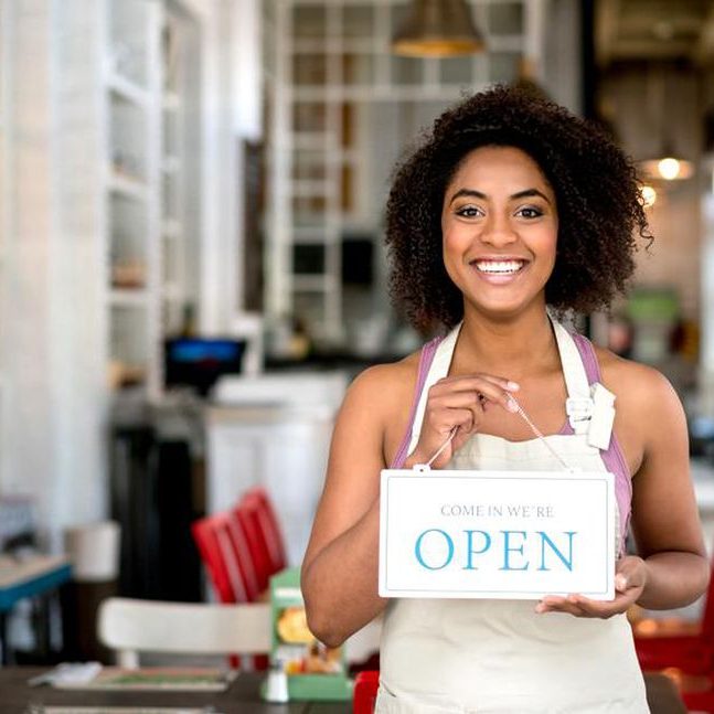 Woman holding an "open" sign