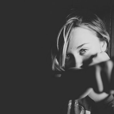 Woman punching at the camera, showing resilience.
