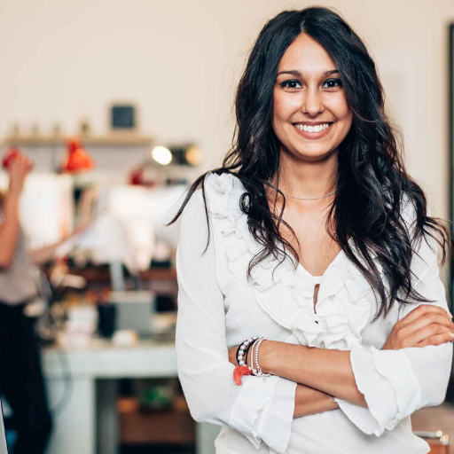 Salon entrepreneur standing with her arms crossed and smiling.
